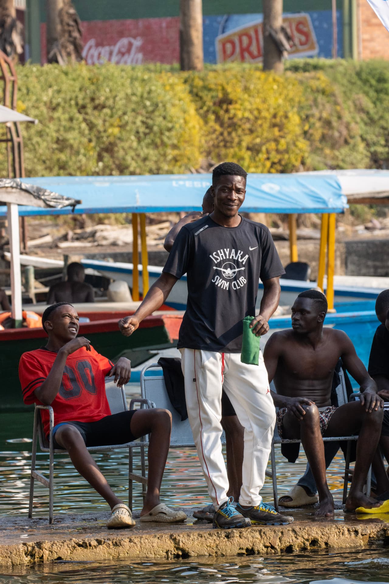 An Ishyaka coach supporting swimmers from the lakeshore